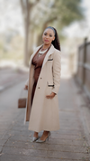 a model in a vintage Jill Jr. tan luxe longline trench with a black trim in a size lage